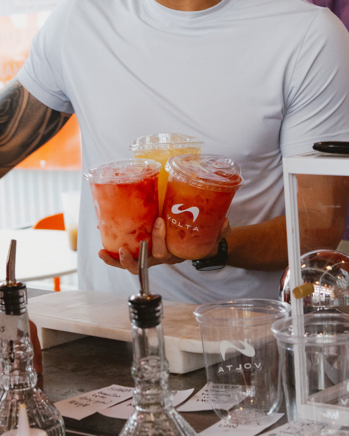 A Volta customer holding two drinks