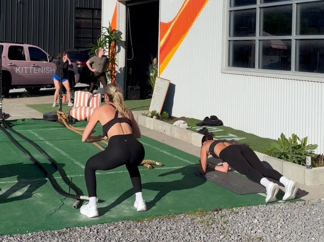 Volta members training on the turf with battle ropes